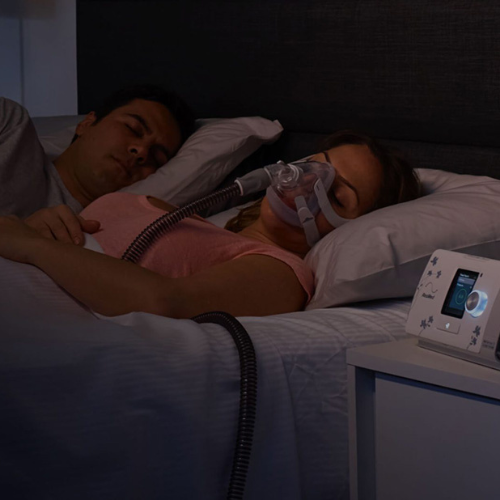 Person sleeping while wearing the ResMed AirTouch F20 full face mask