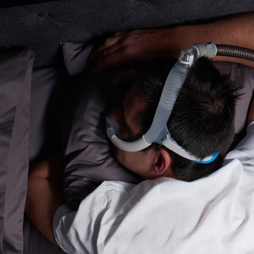 Person sleeping while wearing the ResMed AirFit N30i nasal cradle mask