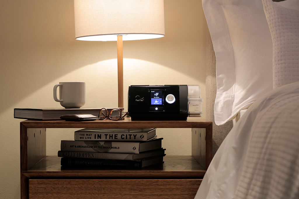 ResMed AirSense 10 CPAP machine on a bedside nightstand